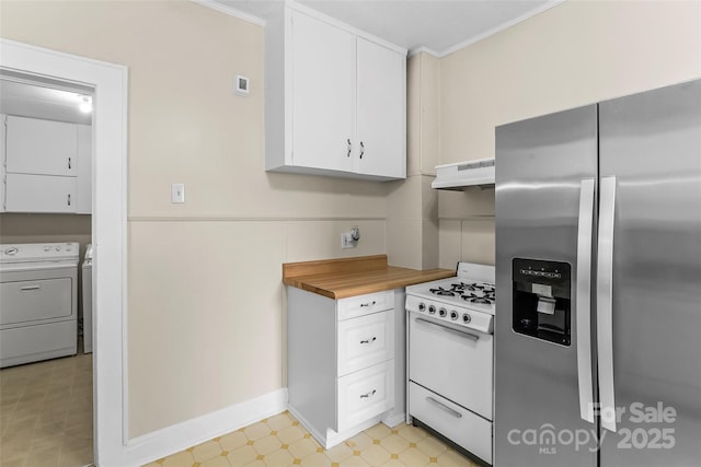 kitchen with stainless steel fridge, gas range gas stove, under cabinet range hood, washing machine and dryer, and light floors