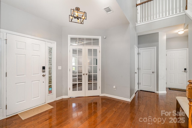 foyer featuring french doors, wood finished floors, and visible vents