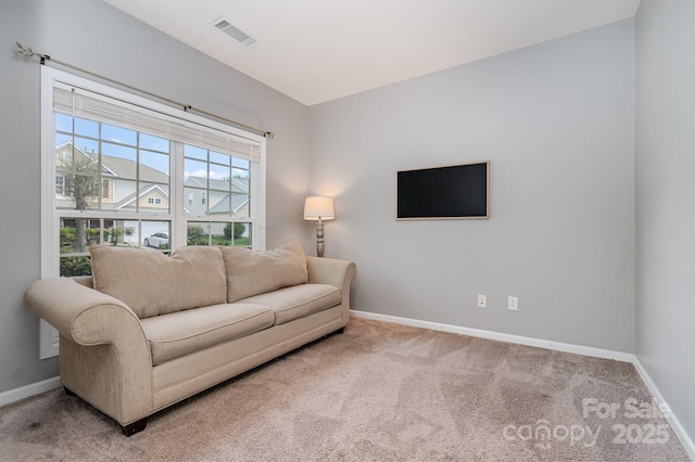 living area featuring visible vents, baseboards, and carpet