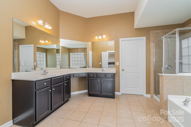 bathroom featuring a bath, a stall shower, vanity, and tile patterned floors