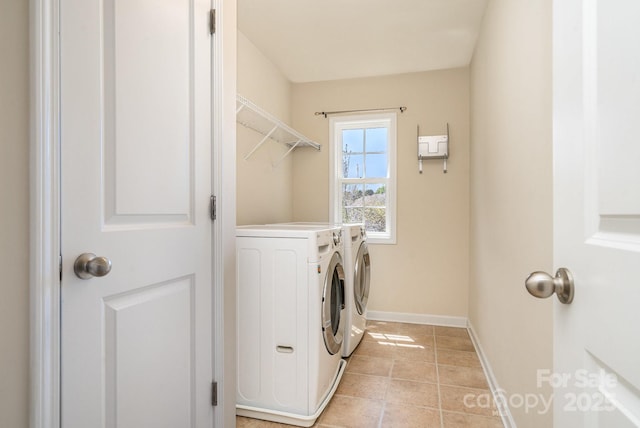 laundry room with washer and clothes dryer, light tile patterned floors, laundry area, and baseboards