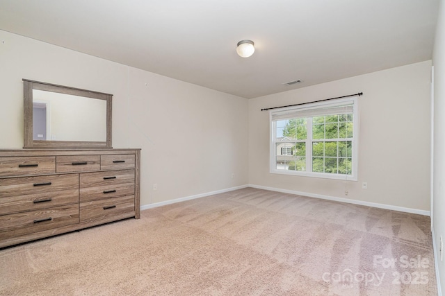 unfurnished bedroom with visible vents, baseboards, and light colored carpet