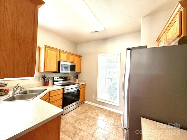 4130 Town Center Rd, Harrisburg, NC 28075 - kitchen featuring stainless steel appliances, a sink, light countertops, and baseboards