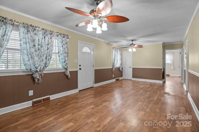 394 Efird St, Gastonia, NC 28054 - entrance foyer featuring wood finished floors, visible vents, a ceiling fan, ornamental molding, and a textured ceiling