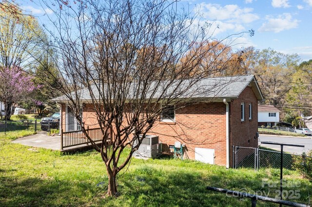 394 Efird St, Gastonia, NC 28054 - view of property exterior with fence, a lawn, brick siding, and central AC