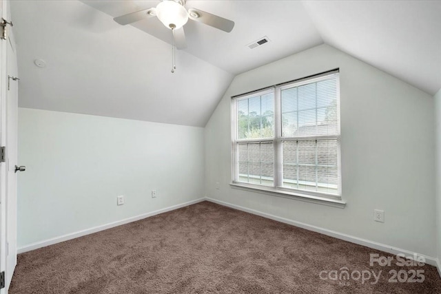 additional living space with carpet floors, baseboards, visible vents, and lofted ceiling