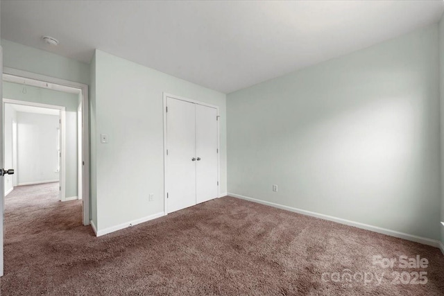unfurnished bedroom featuring baseboards, a closet, and carpet