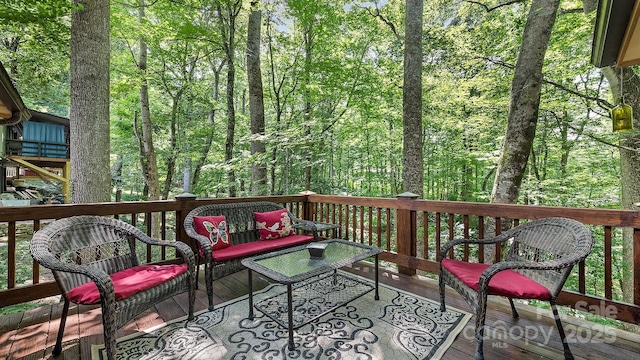 deck with a forest view and an outdoor hangout area