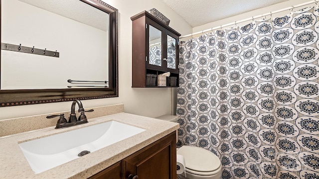 full bath with vanity, curtained shower, toilet, and a textured ceiling