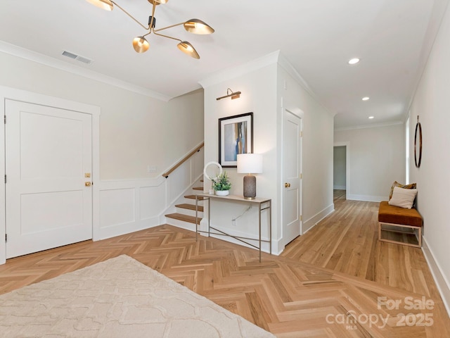 2909 Hanson Dr, Charlotte, NC 28207 - entrance foyer featuring an inviting chandelier, recessed lighting, crown molding, a wainscoted wall, and visible vents