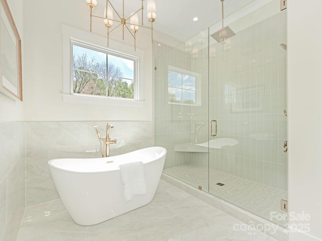 2909 Hanson Dr, Charlotte, NC 28207 - bathroom featuring an inviting chandelier, a stall shower, a soaking tub, recessed lighting, and tile walls
