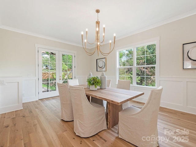 2909 Hanson Dr, Charlotte, NC 28207 - dining space with light wood-style floors, an inviting chandelier, french doors, and crown molding
