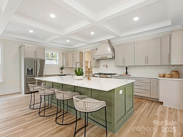 2909 Hanson Dr, Charlotte, NC 28207 - kitchen with a kitchen breakfast bar, custom range hood, light countertops, light wood finished floors, and high end fridge