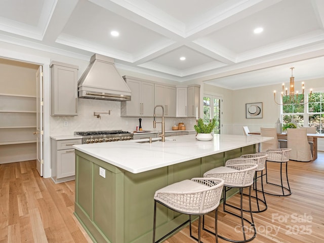 2909 Hanson Dr, Charlotte, NC 28207 - kitchen with light wood finished floors, custom range hood, a sink, and stainless steel gas cooktop
