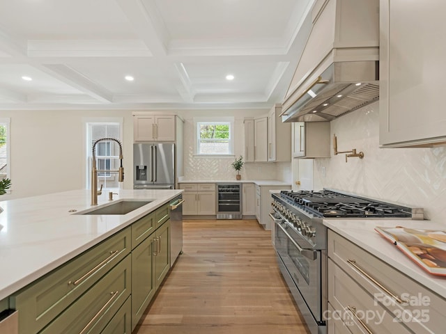 2909 Hanson Dr, Charlotte, NC 28207 - kitchen with a sink, stainless steel appliances, custom range hood, light wood-style flooring, and beverage cooler