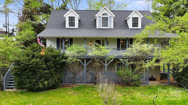 view of front of home with a front yard, cooling unit, and a shingled roof