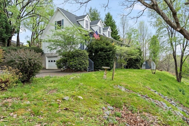 view of yard with an outdoor structure, a garage, and a shed