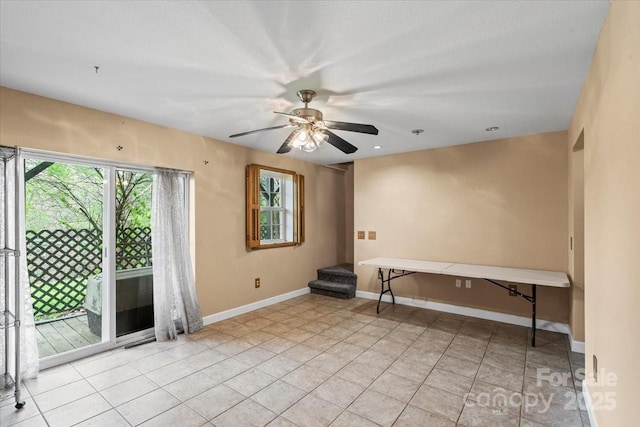 unfurnished room with a wealth of natural light, light tile patterned floors, baseboards, and ceiling fan