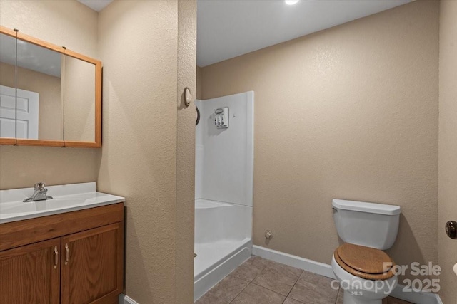 full bathroom featuring vanity, baseboards, tile patterned flooring, walk in shower, and toilet