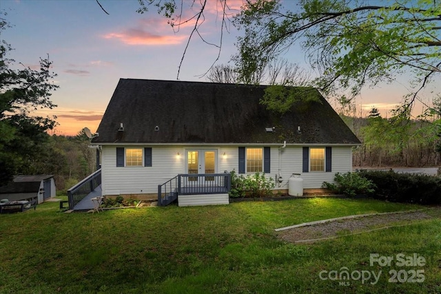 back of house with french doors and a lawn