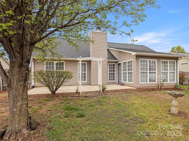 135 S Sunberry Trl, Fletcher, NC 28732 - back of property featuring a patio, roof with shingles, a yard, and a chimney