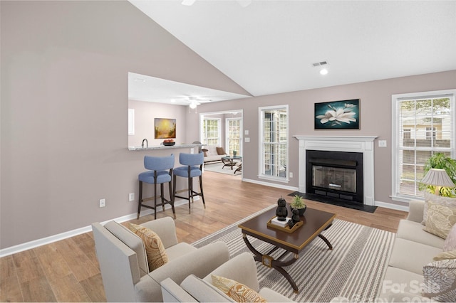 135 S Sunberry Trl, Fletcher, NC 28732 - living room featuring visible vents, a ceiling fan, light wood finished floors, a fireplace with flush hearth, and lofted ceiling