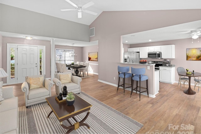 135 S Sunberry Trl, Fletcher, NC 28732 - living room with visible vents, baseboards, a ceiling fan, light wood-style floors, and high vaulted ceiling