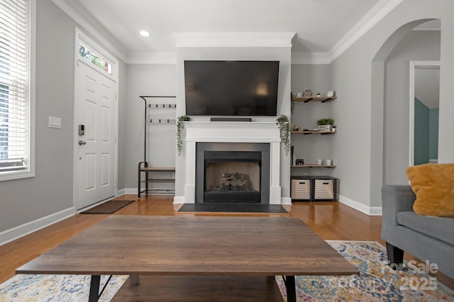 living room featuring wood finished floors, baseboards, ornamental molding, and recessed lighting
