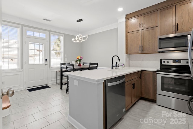 kitchen featuring light tile patterned floors, a peninsula, visible vents, appliances with stainless steel finishes, and a sink