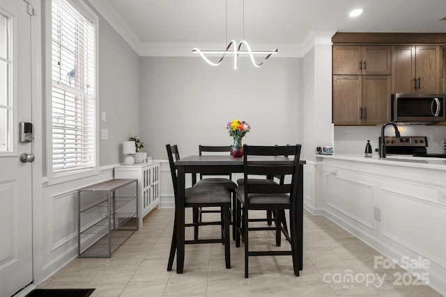 dining room with crown molding, a decorative wall, recessed lighting, light tile patterned flooring, and a notable chandelier