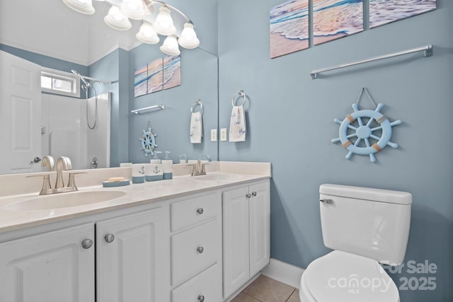 full bath with double vanity, tile patterned floors, toilet, and a sink