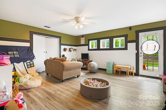 living area featuring visible vents, wood finished floors, and ceiling fan