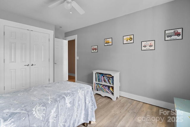 bedroom featuring a closet, light wood-style floors, baseboards, and ceiling fan