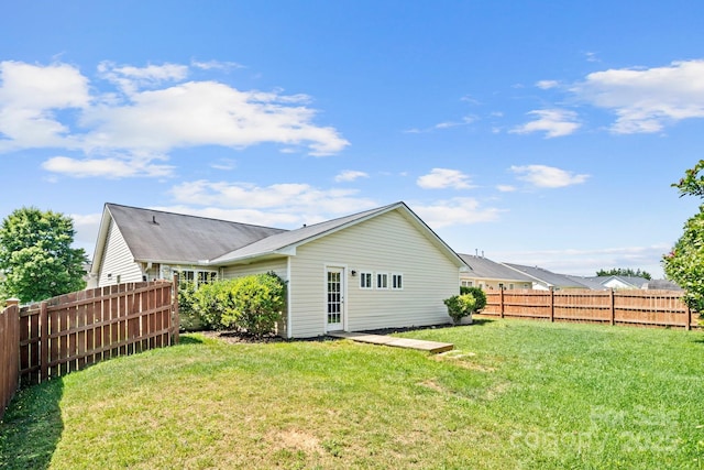 rear view of property with a yard and fence
