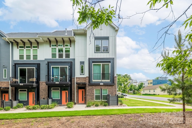 648 W End Dr, Charlotte, NC 28208 - townhome / multi-family property with brick siding, board and batten siding, a balcony, and a front lawn