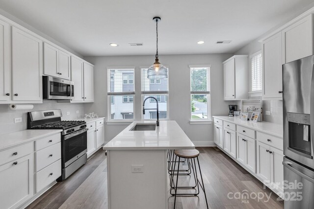 648 W End Dr, Charlotte, NC 28208 - kitchen with stainless steel appliances, a sink, white cabinetry, an island with sink, and recessed lighting