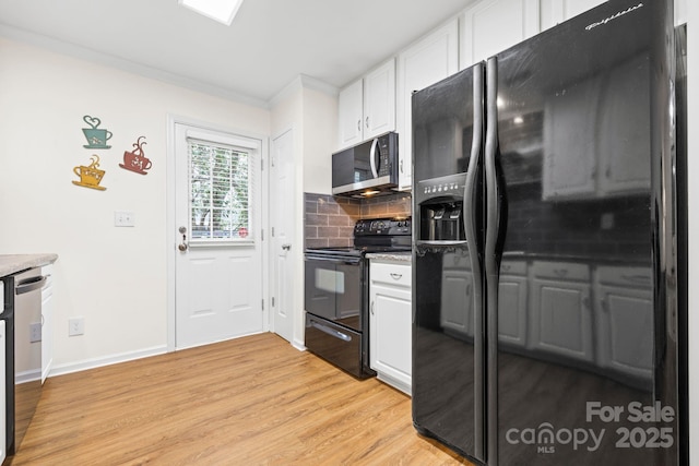 kitchen featuring white cabinetry, light wood-style flooring, black appliances, and decorative backsplash