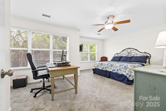 carpeted bedroom with ornamental molding, visible vents, baseboards, and a ceiling fan