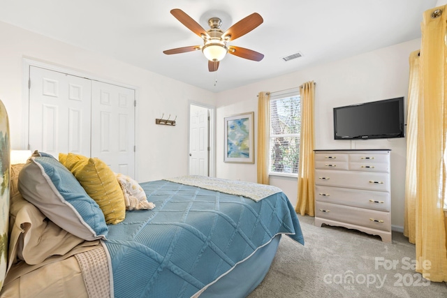 bedroom featuring visible vents, a ceiling fan, carpet flooring, and a closet