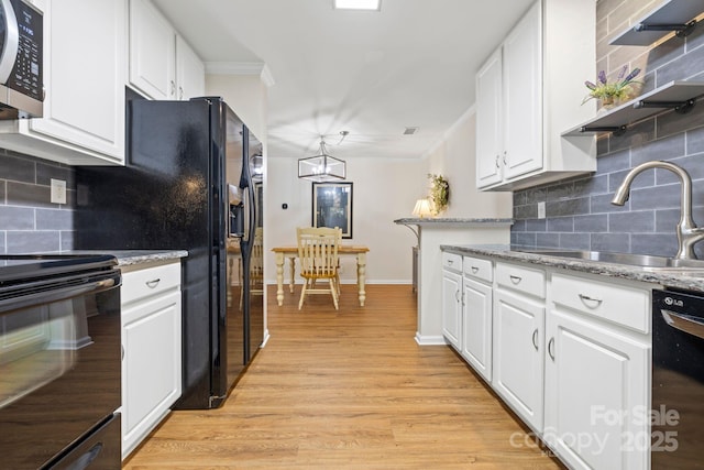kitchen featuring a sink, tasteful backsplash, black appliances, and crown molding