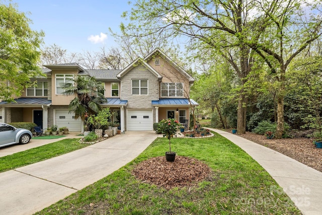view of front of home with a standing seam roof, metal roof, a front lawn, a garage, and driveway