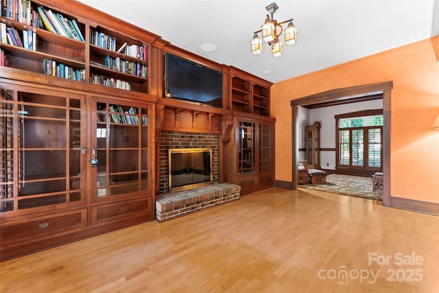 unfurnished living room with baseboards, wood finished floors, and a fireplace
