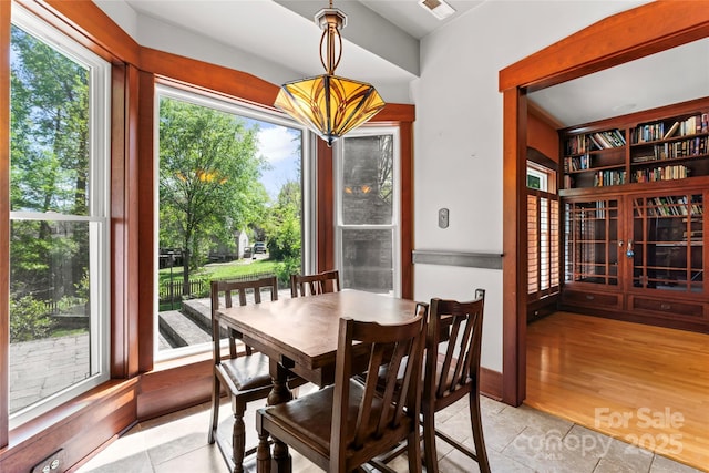 dining area featuring light wood finished floors and visible vents