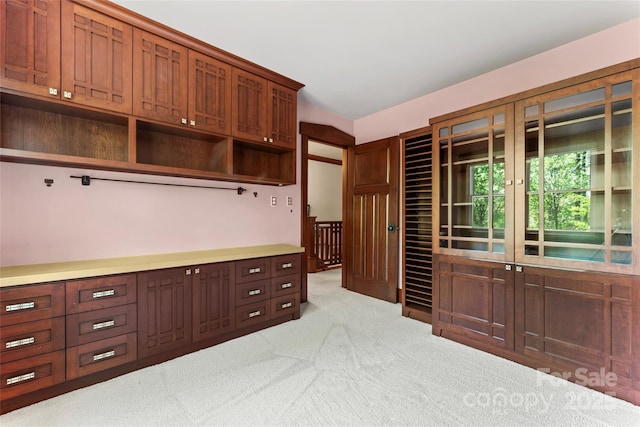 kitchen with light countertops, open shelves, and carpet