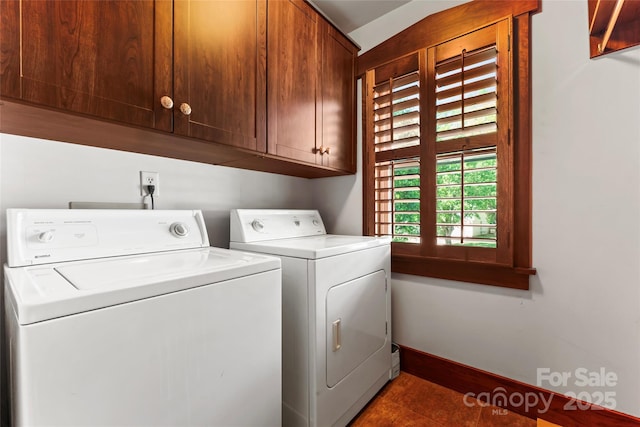 clothes washing area with cabinet space, tile patterned floors, washer and clothes dryer, and baseboards