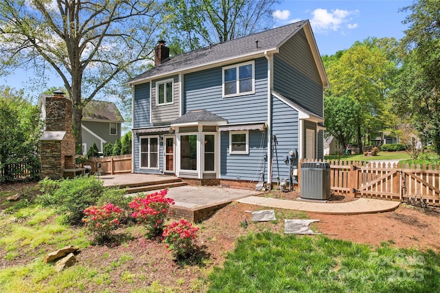 back of property with a patio area, fence, central AC, and a chimney