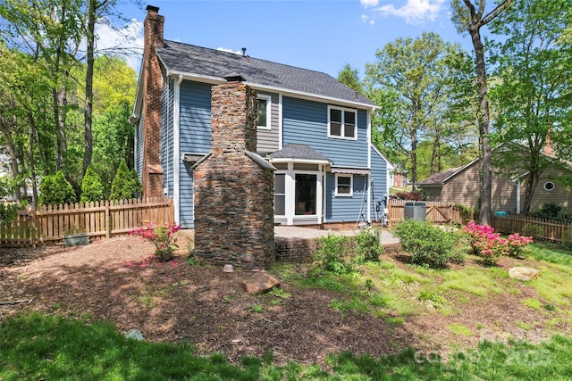 rear view of property with a patio area, fence, and a chimney