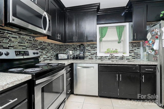 8301 Washington Blvd, Charlotte, NC 28262 - kitchen featuring dark cabinets, backsplash, light tile patterned flooring, stainless steel appliances, and a sink