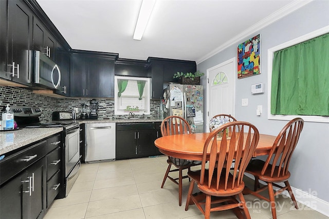 8301 Washington Blvd, Charlotte, NC 28262 - kitchen featuring light countertops, appliances with stainless steel finishes, dark cabinets, crown molding, and backsplash