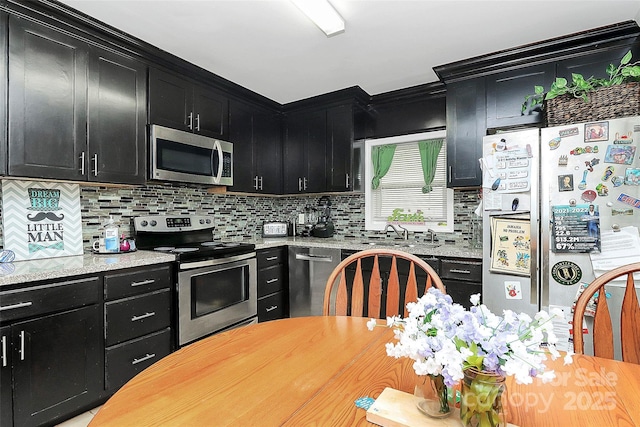 8301 Washington Blvd, Charlotte, NC 28262 - kitchen featuring a sink, decorative backsplash, dark cabinetry, and appliances with stainless steel finishes
